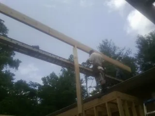 Carpenter setting a ridge beam over a new addition frame — Ice Dam Removal by Roofing Brothers in Sun Prairie