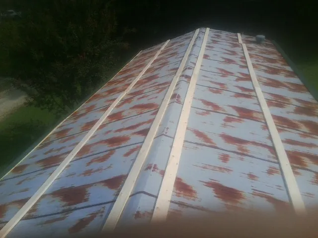 Rusted metal roof panels with new wood purlins before replacement — Storm Damage Roof Repair in Sun Prairie by Roofing Brothers