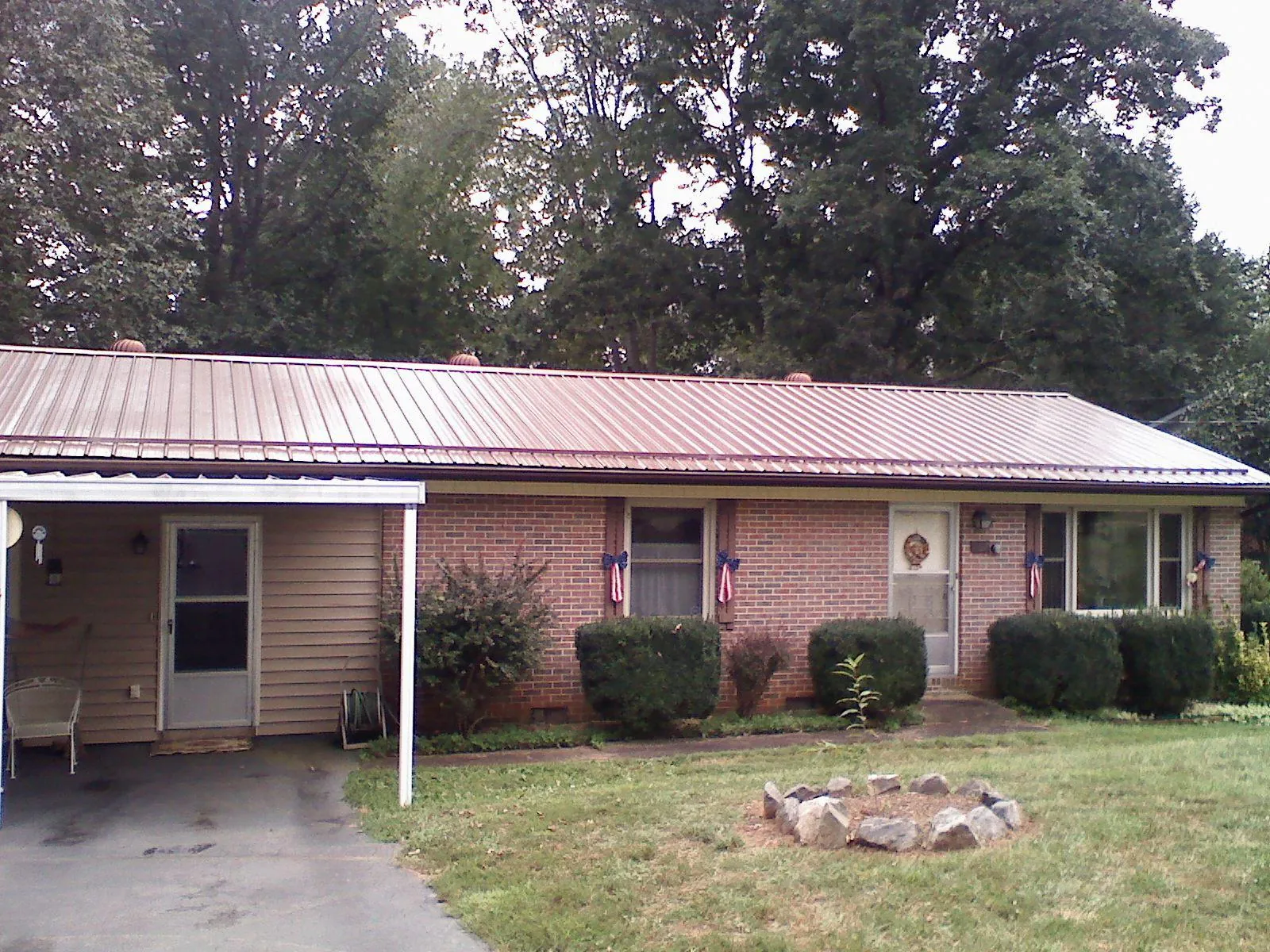 Bronze metal roof and carport on a brick ranch home — Roof Repair work by our crew in Sun Prairie