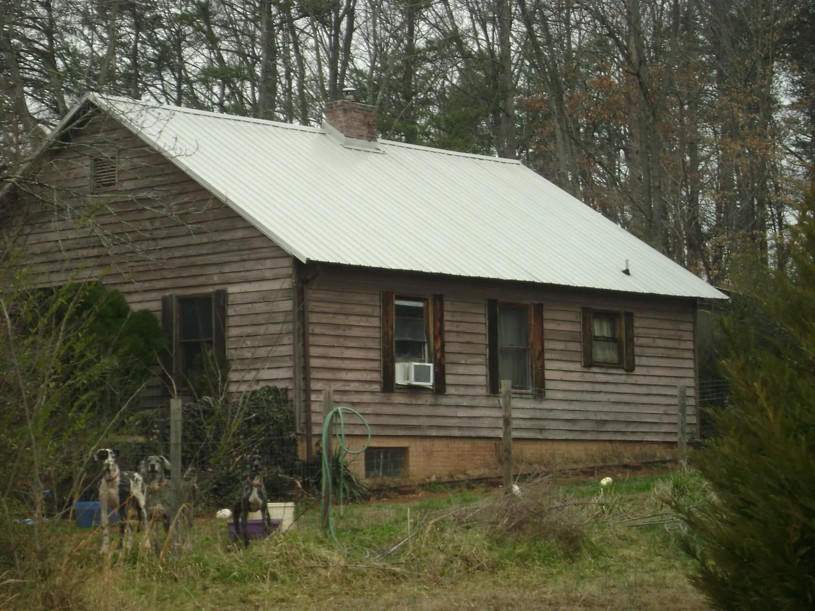 White metal roof on an old wood sided farmhouse, from a Asphalt Shingle Roof Repair job in Sun Prairie